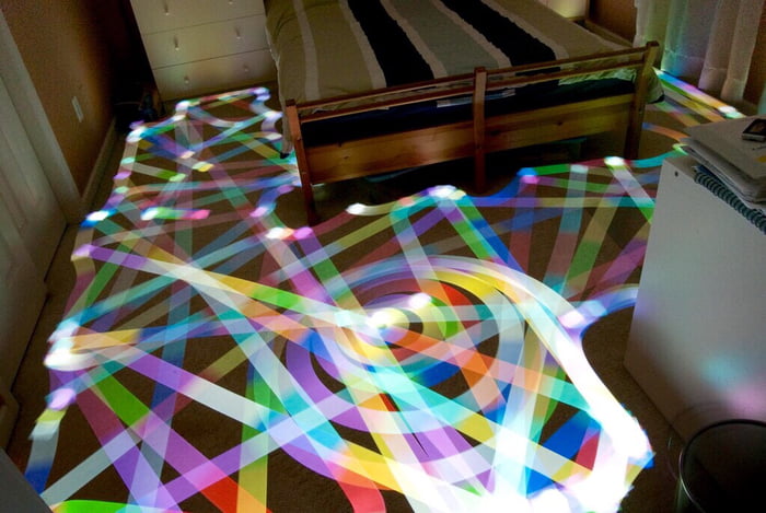 Long Exposure of a Roomba Vacuum with a Color Changing Light on Top.