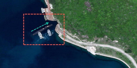 Tug boats guiding a Chinese submarine into a secret underground base.